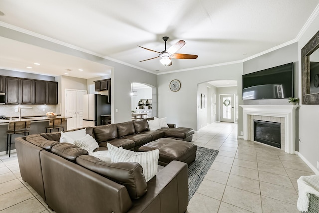 16802 Cherokee Lake Ln, Houston, TX 77044 - living room with arched walkways, light tile patterned flooring, a ceiling fan, a tile fireplace, and crown molding