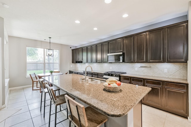 16802 Cherokee Lake Ln, Houston, TX 77044 - kitchen with range with gas stovetop, a sink, stainless steel microwave, backsplash, and recessed lighting