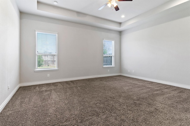 4926 Thunder Creek Ln, Sugar Land, TX 77479 - empty room featuring dark carpet, ceiling fan, a tray ceiling, baseboards, and recessed lighting