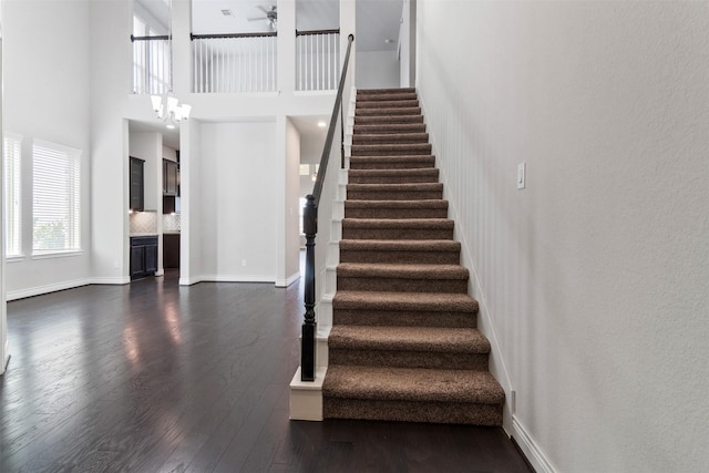 4926 Thunder Creek Ln, Sugar Land, TX 77479 - staircase featuring wood finished floors, ceiling fan, baseboards, a chandelier, and a high ceiling