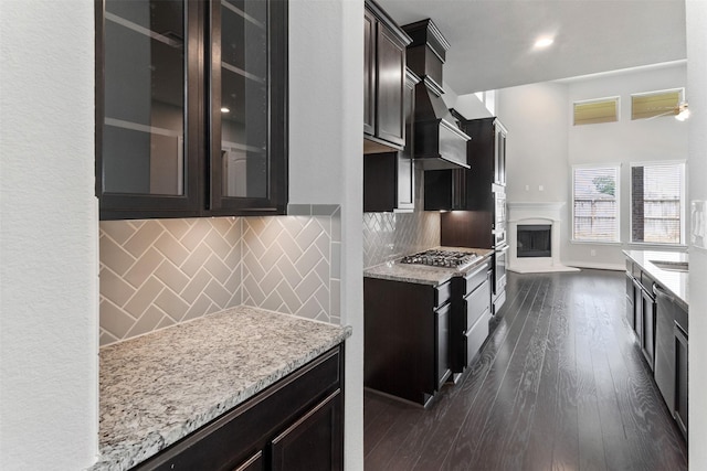 4926 Thunder Creek Ln, Sugar Land, TX 77479 - kitchen featuring appliances with stainless steel finishes, light stone countertops, decorative backsplash, and a fireplace with raised hearth