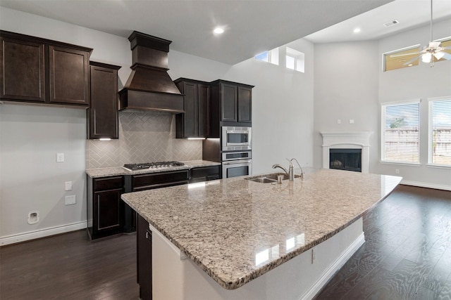 4926 Thunder Creek Ln, Sugar Land, TX 77479 - kitchen featuring a sink, custom range hood, dark wood-type flooring, light stone countertops, and ceiling fan