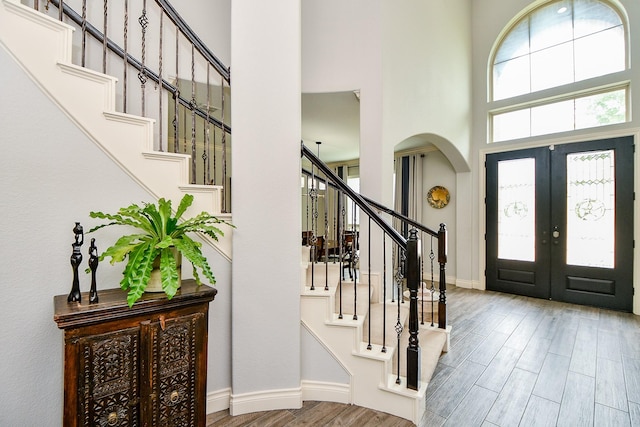 29016 Concan Crossing Ct, Katy, TX 77494 - foyer entrance with french doors, arched walkways, a towering ceiling, stairway, and wood finished floors
