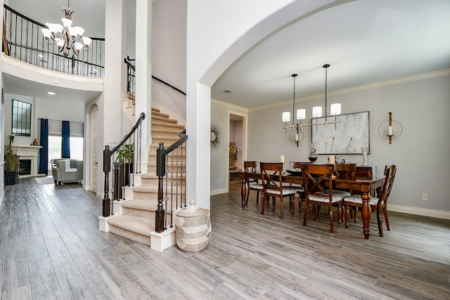 29016 Concan Crossing Ct, Katy, TX 77494 - dining room featuring a chandelier, stairway, baseboards, wood finished floors, and ornamental molding