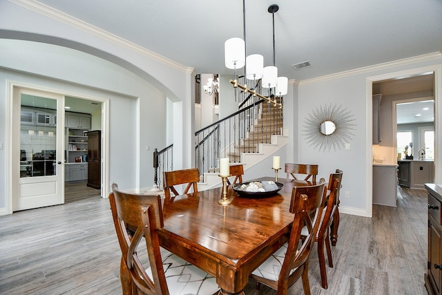 29016 Concan Crossing Ct, Katy, TX 77494 - dining room with a chandelier, light wood-style flooring, stairway, ornamental molding, and baseboards