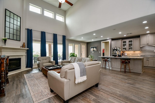 29016 Concan Crossing Ct, Katy, TX 77494 - living area with a high ceiling, ceiling fan, dark wood finished floors, recessed lighting, and a glass covered fireplace