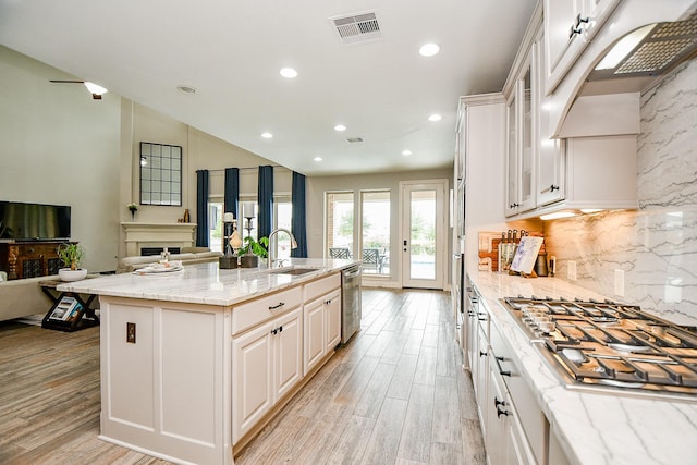 29016 Concan Crossing Ct, Katy, TX 77494 - kitchen featuring open floor plan, appliances with stainless steel finishes, light stone countertops, tasteful backsplash, and light wood finished floors