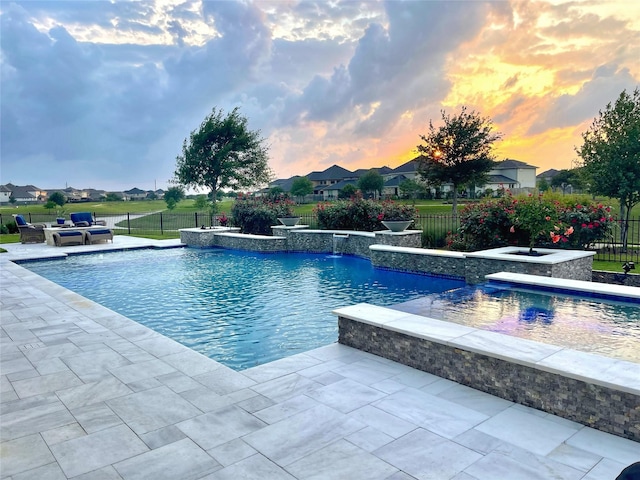 29016 Concan Crossing Ct, Katy, TX 77494 - pool at dusk with outdoor lounge area, a fenced backyard, a jacuzzi, and a patio