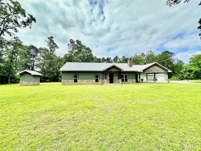 4815 Fm 2827th Rd, Warren, TX 77664 - view of front of home with a chimney, stone siding, a front lawn, board and batten siding, and metal roof