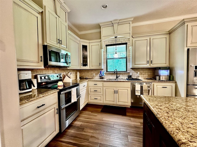 4815 Fm 2827th Rd, Warren, TX 77664 - kitchen with appliances with stainless steel finishes, a sink, cream cabinetry, ornamental molding, and dark wood-type flooring
