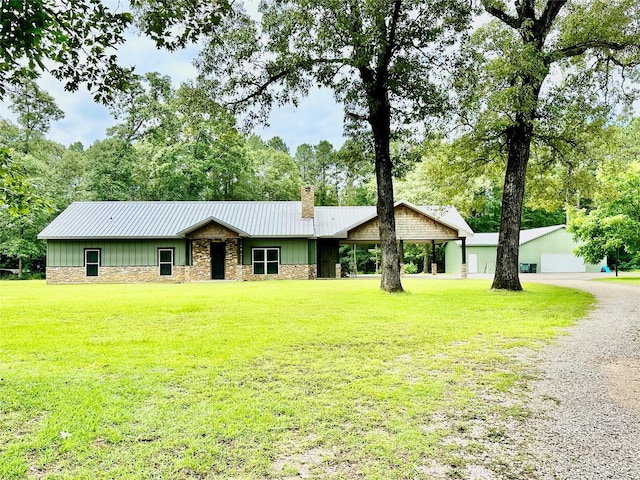 4815 Fm 2827th Rd, Warren, TX 77664 - view of front of house with a chimney, a front yard, board and batten siding, stone siding, and metal roof