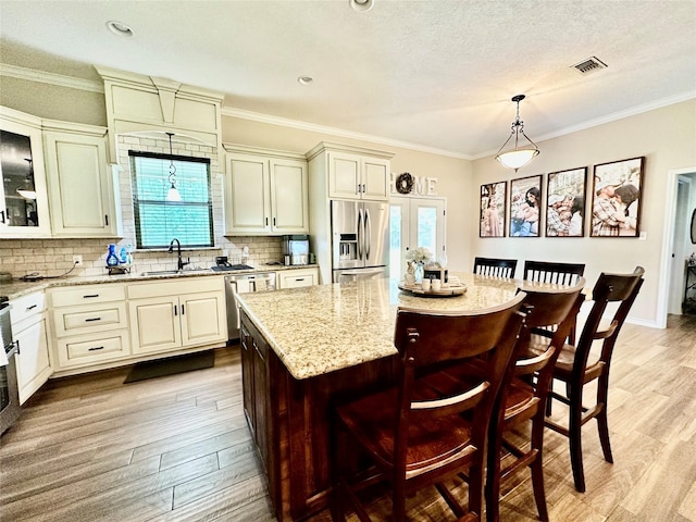 4815 Fm 2827th Rd, Warren, TX 77664 - kitchen featuring appliances with stainless steel finishes, a sink, plenty of natural light, light wood-type flooring, and ornamental molding