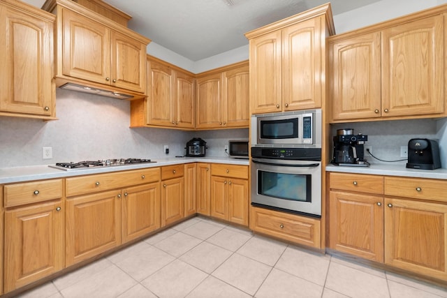 197 Westwood Dr E, Trinity, TX 75862 - kitchen featuring appliances with stainless steel finishes, light countertops, light tile patterned flooring, and backsplash