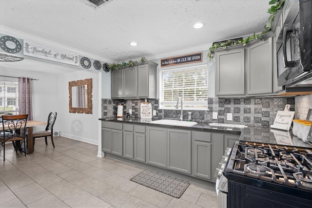1406 Grand Valley Dr, Houston, TX 77090 - kitchen featuring a sink, gray cabinets, black microwave, stainless steel gas range, and dark countertops