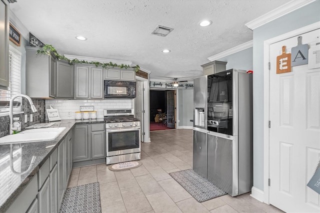 1406 Grand Valley Dr, Houston, TX 77090 - kitchen featuring appliances with stainless steel finishes, gray cabinetry, a sink, ornamental molding, and tasteful backsplash
