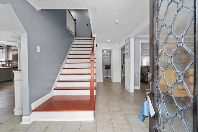 1406 Grand Valley Dr, Houston, TX 77090 - entryway featuring ornamental molding, baseboards, stairs, light tile patterned flooring, and a textured ceiling