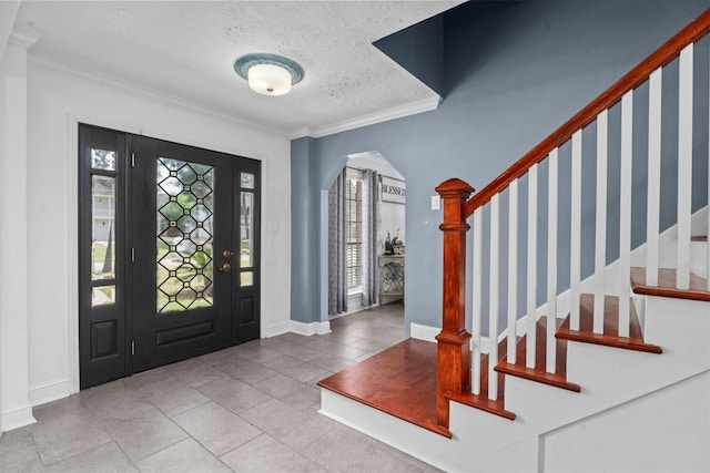 1406 Grand Valley Dr, Houston, TX 77090 - tiled foyer entrance with stairs, a textured ceiling, ornamental molding, arched walkways, and baseboards