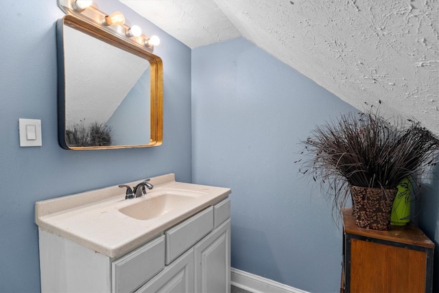1406 Grand Valley Dr, Houston, TX 77090 - bathroom with vaulted ceiling, vanity, baseboards, and a textured ceiling