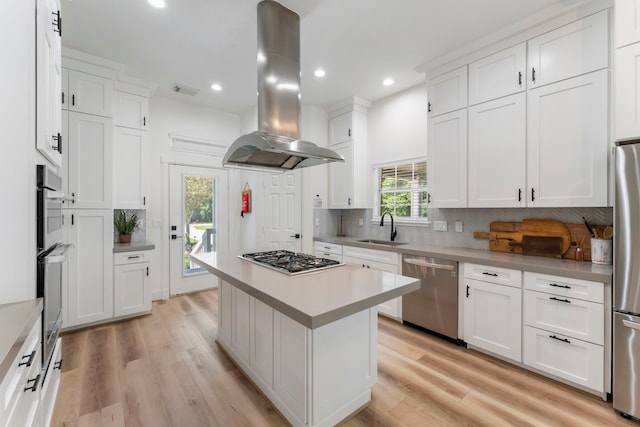 3714 Falun Ct, Spring, TX 77386 - kitchen with appliances with stainless steel finishes, island range hood, a sink, light countertops, and backsplash