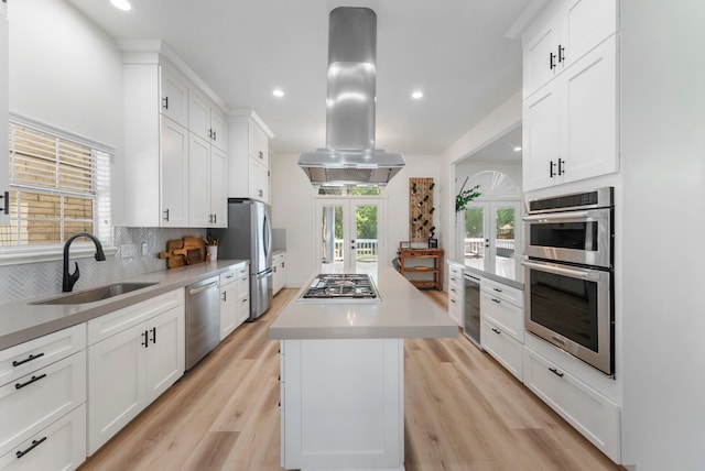 3714 Falun Ct, Spring, TX 77386 - kitchen featuring a sink, appliances with stainless steel finishes, island range hood, french doors, and decorative backsplash