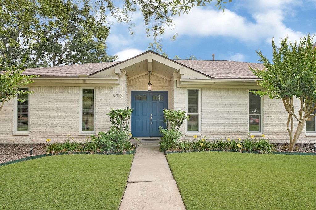 9015 Landsdowne Dr, Houston, TX 77096 - view of front of home featuring brick siding, a front lawn, and a shingled roof
