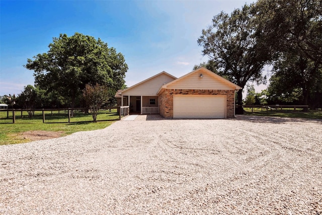 22035 Buescher Rd, Tomball, TX 77377 - ranch-style home featuring gravel driveway, a garage, and brick siding