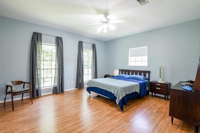 22035 Buescher Rd, Tomball, TX 77377 - bedroom with light wood finished floors, baseboards, and a ceiling fan