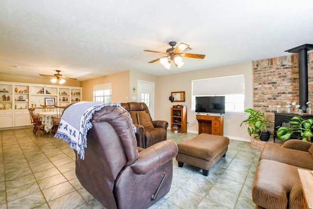 22035 Buescher Rd, Tomball, TX 77377 - living room with ceiling fan, a wood stove, and light tile patterned floors