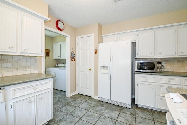 22035 Buescher Rd, Tomball, TX 77377 - kitchen with white refrigerator with ice dispenser, stainless steel microwave, backsplash, washing machine and clothes dryer, and a textured ceiling