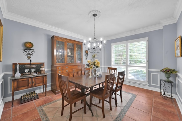 7 Newland Ct, The Woodlands, TX 77382 - dining space featuring inlaid floor details, a chandelier, light tile patterned floors, and ornamental molding