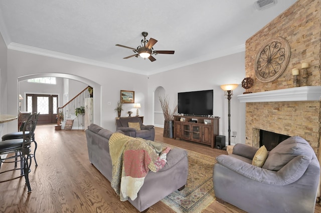 7 Newland Ct, The Woodlands, TX 77382 - living room featuring arched walkways, a ceiling fan, crown molding, and wood finished floors