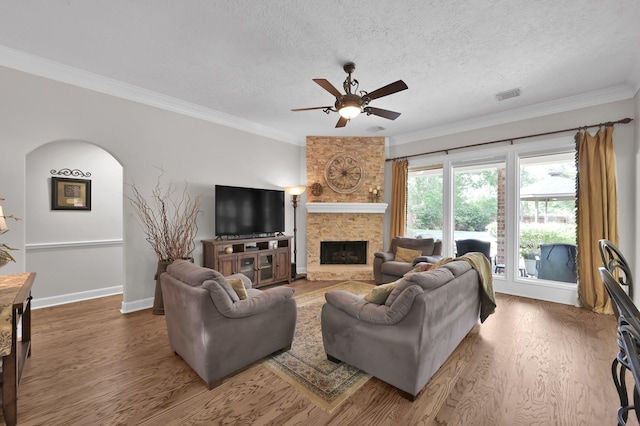 7 Newland Ct, The Woodlands, TX 77382 - living room with a ceiling fan, ornamental molding, wood finished floors, a textured ceiling, and a fireplace