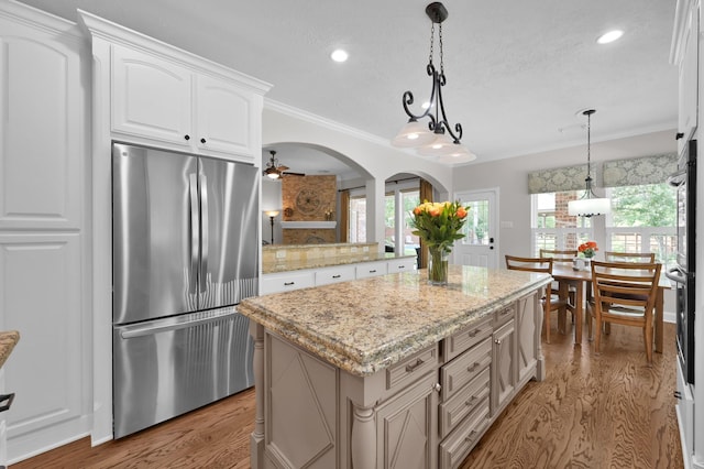 7 Newland Ct, The Woodlands, TX 77382 - kitchen with freestanding refrigerator, light wood-style floors, recessed lighting, a ceiling fan, and crown molding