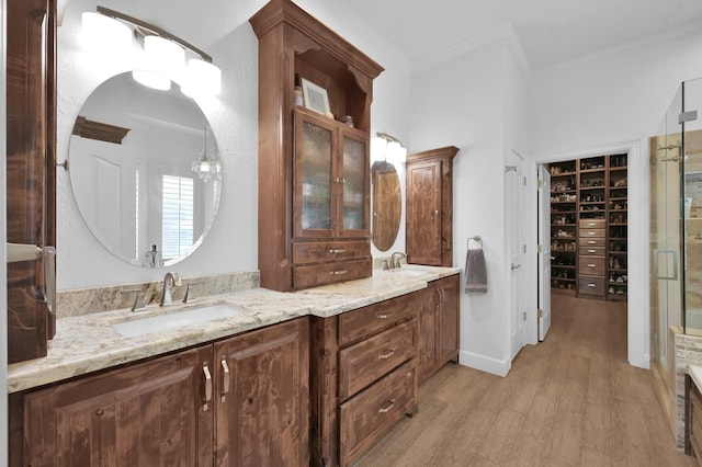 7 Newland Ct, The Woodlands, TX 77382 - full bathroom featuring ornamental molding, double vanity, wood finished floors, and a walk in closet