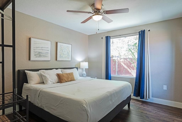 5213 Claremont St, Houston, TX 77023 - bedroom with dark wood-style floors, baseboards, a textured wall, and a ceiling fan