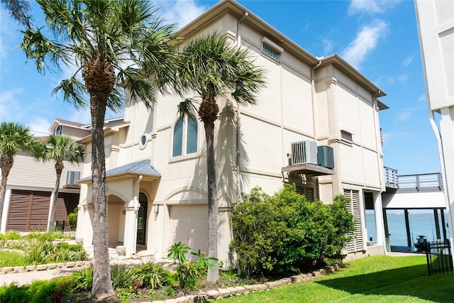1554 Windsong Way, Tiki Island, TX 77554 - view of building exterior with an attached garage and central AC unit