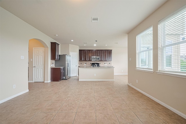 3722 Glover Meadows Ln, Houston, TX 77047 - kitchen with appliances with stainless steel finishes, arched walkways, open floor plan, light countertops, and dark brown cabinets