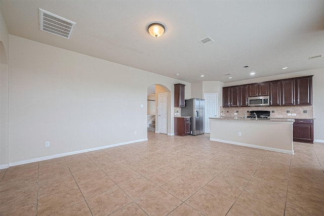 3722 Glover Meadows Ln, Houston, TX 77047 - kitchen featuring appliances with stainless steel finishes, arched walkways, light countertops, light tile patterned floors, and recessed lighting