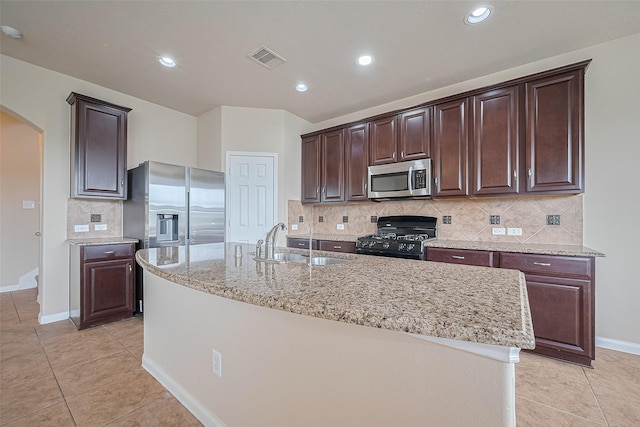 3722 Glover Meadows Ln, Houston, TX 77047 - kitchen with appliances with stainless steel finishes, a sink, arched walkways, light tile patterned floors, and dark brown cabinets