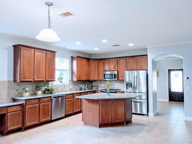 6318 Alpine Trail Ln, Katy, TX 77494 - kitchen with stainless steel appliances, arched walkways, brown cabinets, backsplash, and ornamental molding