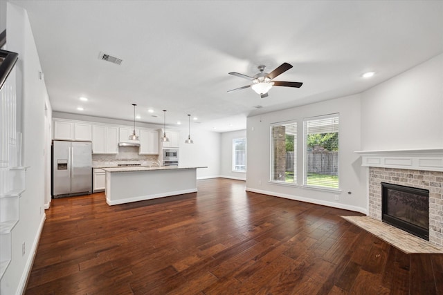12 Centennial Ridge Pl, Magnolia, TX 77354 - unfurnished living room featuring dark wood-style floors, a ceiling fan, recessed lighting, a fireplace, and baseboards