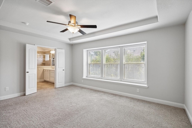 12 Centennial Ridge Pl, Magnolia, TX 77354 - unfurnished bedroom with carpet, baseboards, connected bathroom, and a tray ceiling