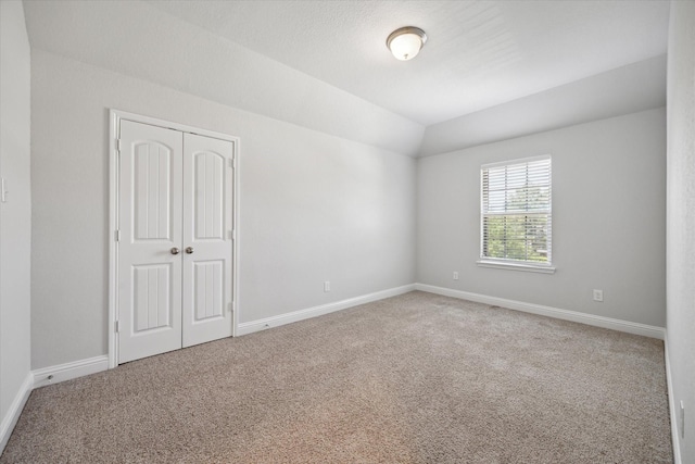 12 Centennial Ridge Pl, Magnolia, TX 77354 - unfurnished bedroom featuring carpet floors, a closet, baseboards, and lofted ceiling