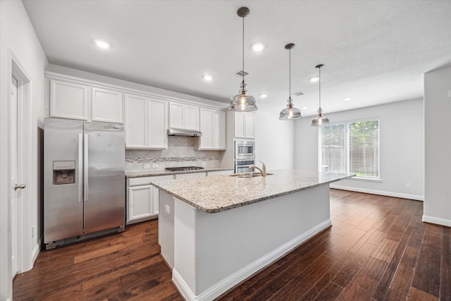 12 Centennial Ridge Pl, Magnolia, TX 77354 - kitchen with stainless steel appliances, a sink, under cabinet range hood, dark wood-style floors, and recessed lighting