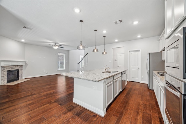 12 Centennial Ridge Pl, Magnolia, TX 77354 - kitchen featuring stainless steel appliances, a sink, a ceiling fan, open floor plan, and a kitchen island with sink