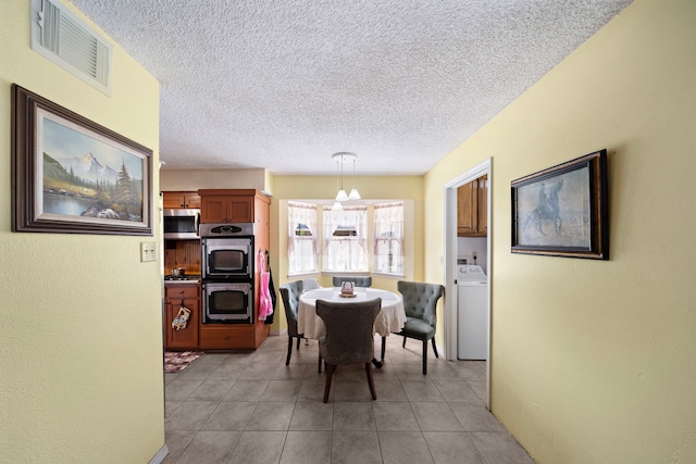 19527 Enchanted Spring Dr, Spring, TX 77388 - dining room with washer / dryer, a textured ceiling, light tile patterned floors, and a textured wall