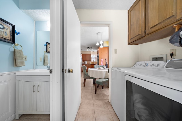 19527 Enchanted Spring Dr, Spring, TX 77388 - washroom with a textured ceiling, cabinet space, separate washer and dryer, and light tile patterned floors