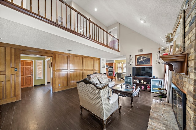 19527 Enchanted Spring Dr, Spring, TX 77388 - living room with a textured ceiling, high vaulted ceiling, dark wood finished floors, and a fireplace