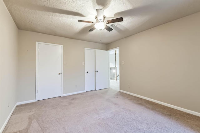 3914 Cherry Forest Dr, Houston, TX 77088 - unfurnished bedroom with carpet floors, a textured ceiling, baseboards, and multiple closets