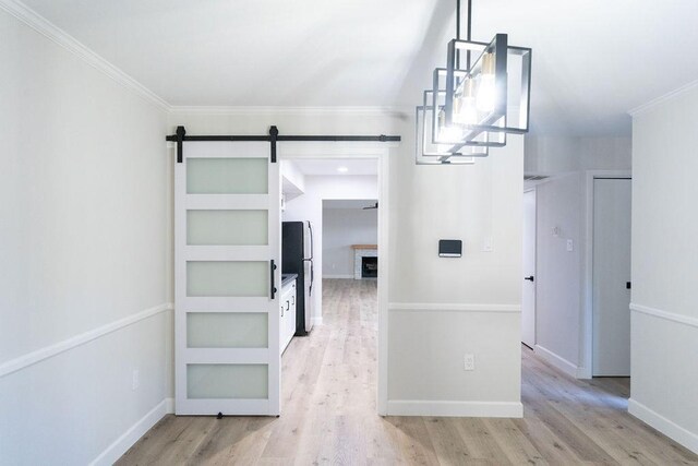 2243 W Alabama St Unit 10, Houston, TX 77098 - corridor with light wood finished floors, ornamental molding, a barn door, and baseboards